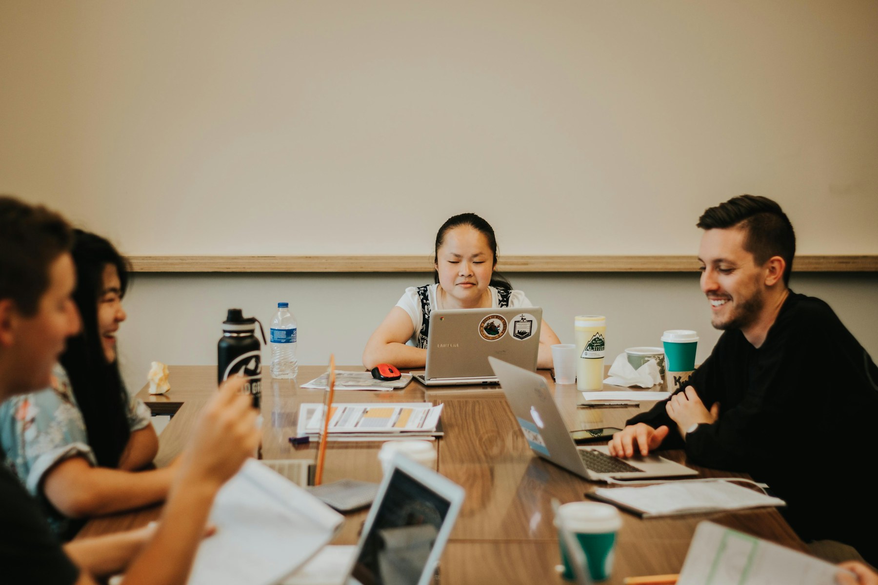 A software team collaborating around laptops in a working session